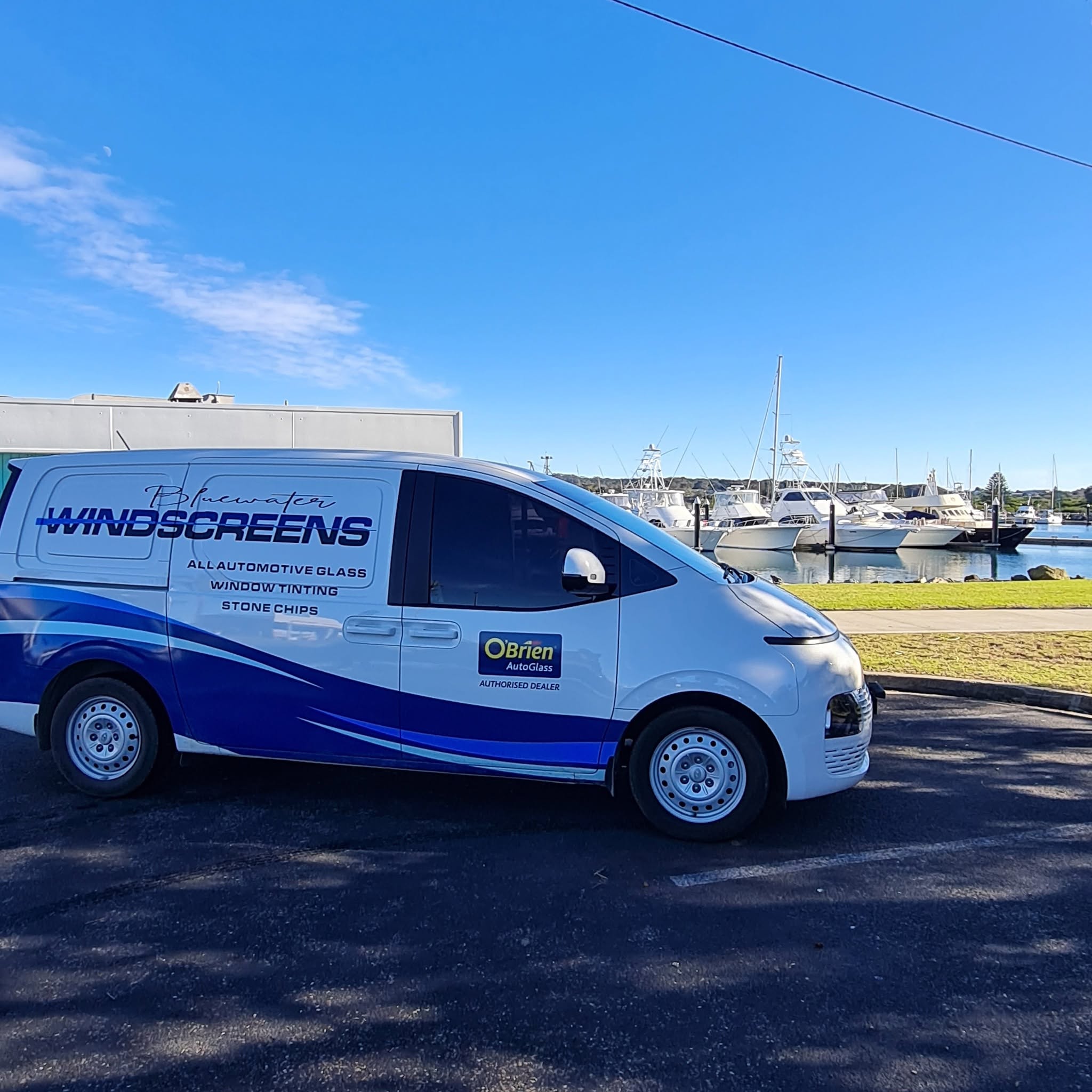 The van parked by a harbour on the far south coast with game fishing boats moored behind it